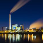 Colorful night view of a modern waste incineration plant in Oberhausen, Germany with deep blue sky.